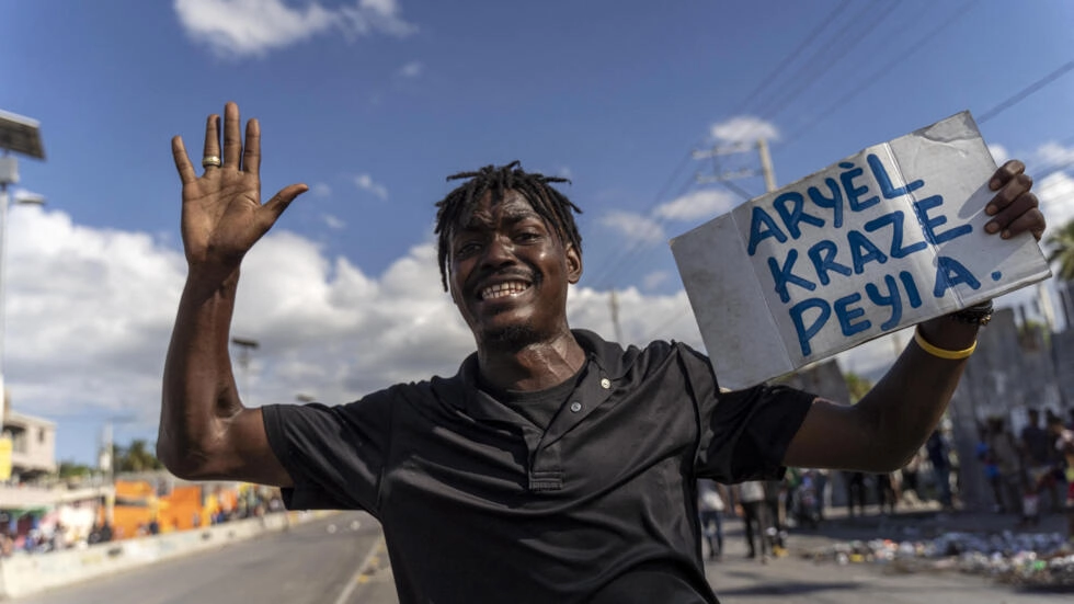 In this file photo a man carries a sign reading "Ariel broke the country" during a protest against Haitian Prime Minister Ariel Henry calling for his resignation, in Port-au-Prince, Haiti, October 10, 2022. © Richard Pierrin, AFP