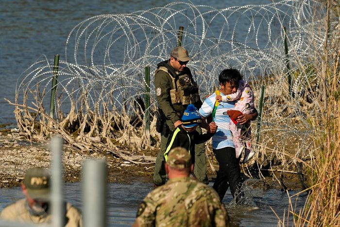Migrants are taken into custody by officials at the U.S.-Mexico border in Eagle Pass, Texas. PHOTO: ERIC GAY/ASSOCIATED PRESS