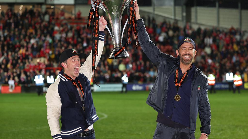 Wrexham owners Rob McElhenney and Ryan Reynolds hold the Vanarama National League Trophy. Photo by Matthew Ashton - AMA/Getty Images.