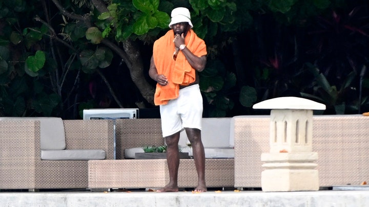 Sean "Diddy" Combs stands on the waterfront side of his Star Island mansion on Saturday, March 30, 2024. (Backgrid/Mega)