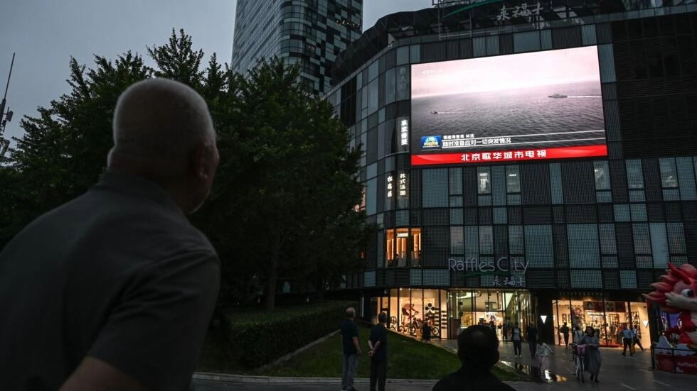 An outdoor screen shows a news coverage of China's military drills around Taiwan, in Beijing on May 23, 2024. © Jade Gao, AFP