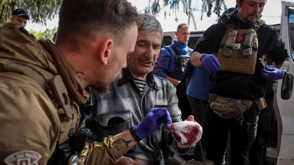 Military paramedics treat a wounded local resident during an evacuation to Kharkiv due to Russian shelling, amid Russia's attack on Ukraine, in Kharkiv region, Ukraine on May 12, 2024. © Vyacheslav Madiyevskyy, Reuters