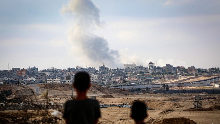 Boys watch smoke billowing during Israeli strikes east of Rafah, Gaza, May 13, 2024 ©  AFP