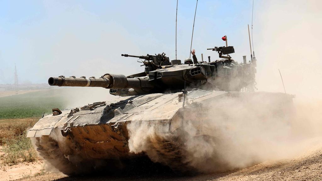 An Israeli army battle tank moves near the border with the Gaza Strip at a location in southern Israel on May 15, 2024, amid the ongoing conflict in the Palestinian territory between Israel and the Hamas movement. (Photo by JACK GUEZ / AFP)