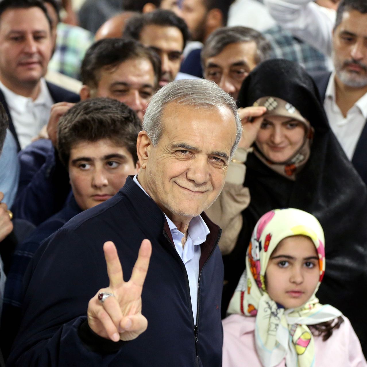 Iranian reformist presidential candidate Masoud Pezeshkian at a polling station Friday, flashing a victory sign. STRINGER/SHUTTERSTOCK