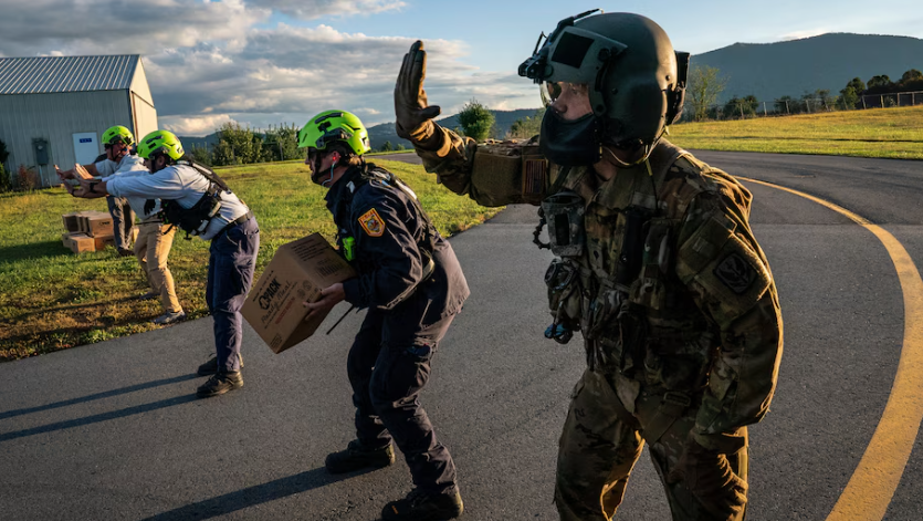 National Guard soldiers, FEMA staff and other aid workers unload food and water from a National Guard helicopter in Jefferson, N.C., on Oct. 2. (Jabin Botsford/The Washington Post)