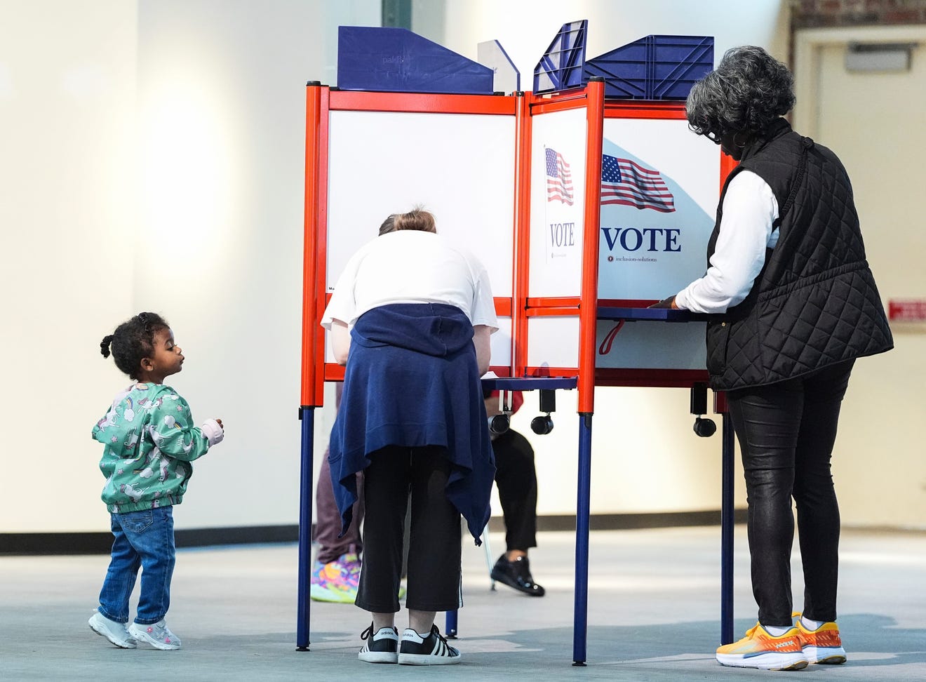 A child takes a peek at the voters at the voting precinct at Kentucky Center For African American Heritage Thursday morning. Oct. 31, 2024. Matt Stone, The Courier Journal Via USA TODAY Network