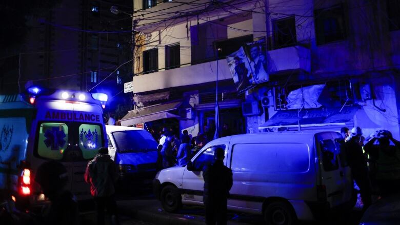 People gather at a damaged site in the aftermath of an Israeli strike in Zuqaq al-Blat area in Beirut, amid the ongoing hostilities between Hezbollah and Israeli forces, in Lebanon Monday. (Thaier Al-Sudani/Reuters)