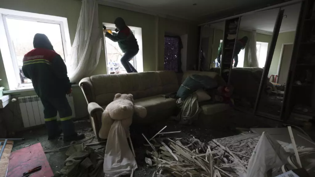 Municipal workers cover windows inside a house damaged by a Russian drone strike on a residential neighbourhood in Zaporizhzhia, Ukraine, Monday Nov. 25, 2024. © Kateryna Klochko, AP