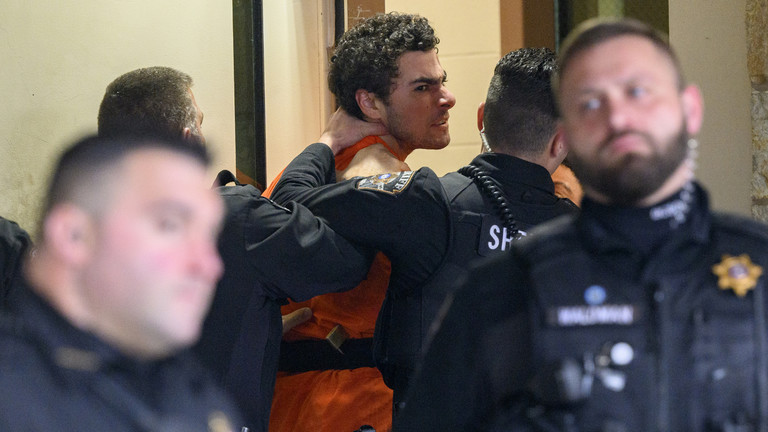 Suspected shooter Luigi Mangione is led into the Blair County Courthouse for an extradition hearing December 10, 2024 in Hollidaysburg, Pennsylvania. ©  Jeff Swensen/Getty Images