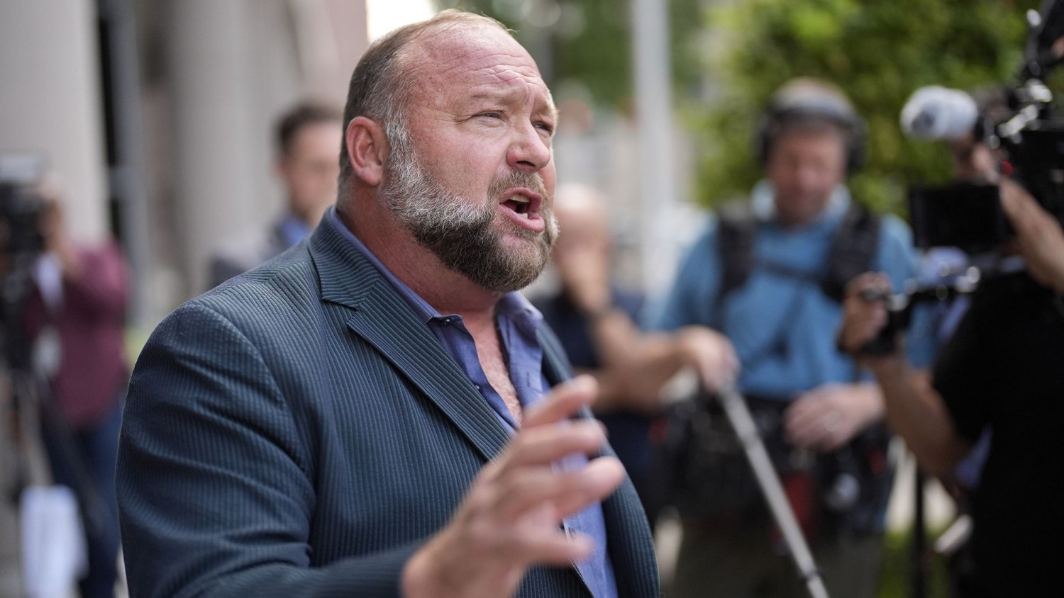 Right-wing conspiracy theorist Alex Jones speaks to the media after arriving at the federal courthouse for a hearing in front of a bankruptcy judge on June 14, 2024, in Houston. David J. Phillip/AP