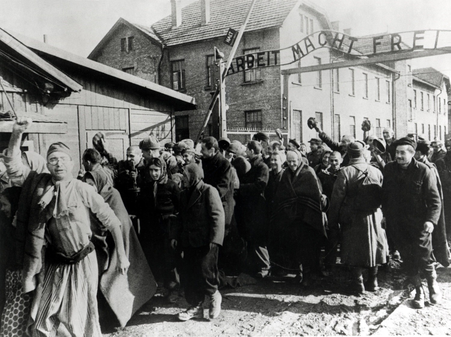 Survivors of Auschwitz leave the concentration camp at the end of World War II in February 1945. Above them is the German slogan Arbeit macht frei, which translates to Work sets you free. Galerie Bilderwelt/Hulton Archive/Getty Images