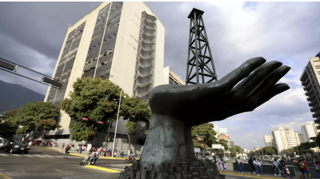 A sculpture of a hand holding an oil drilling rig is pictured outside the state-run oil company Petroleos de Venezuela S.A. in Caracas on February 26, 2025. © Pedro Mattey, AFP