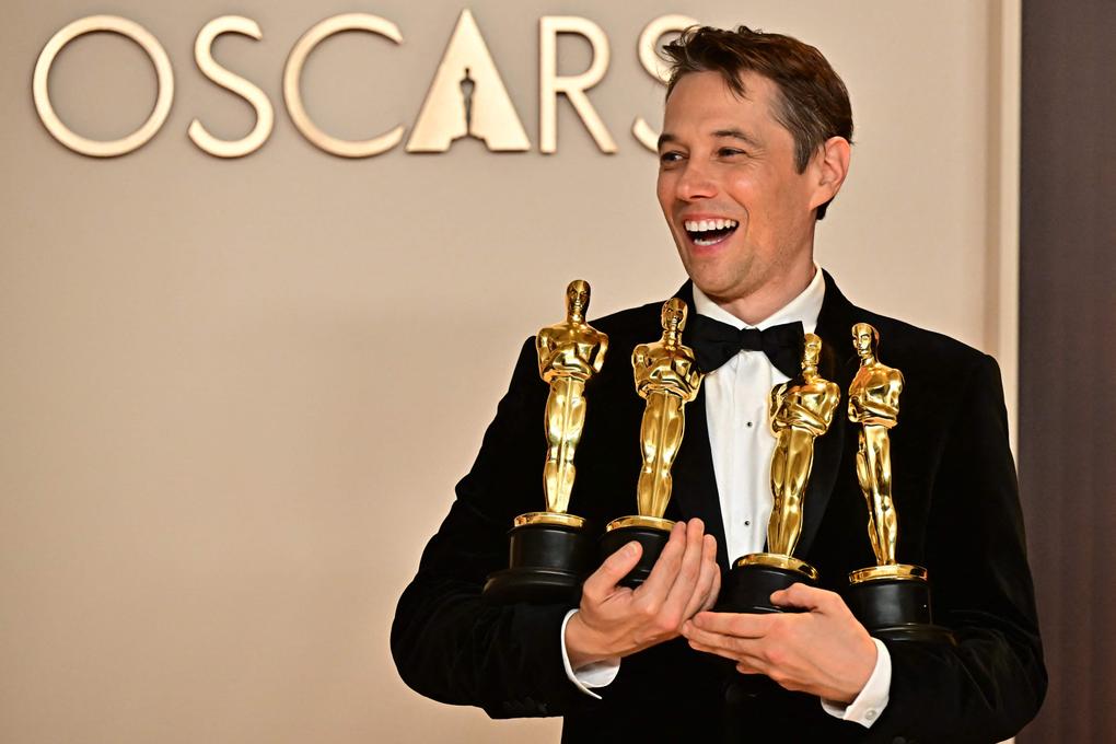 Le réalisateur Sean Baker lors de la 97ᵉ cérémonie des Oscars, au Dolby Theatre, à Hollywood, le 2 mars 2025, avec quatre des cinq statuettes remportées par son film « Anora ». FREDERIC J. BROWN/AFP