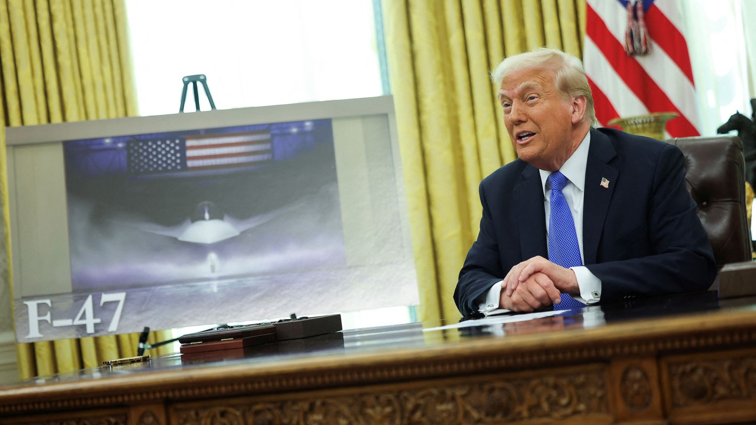 President Donald Trump delivers remarks as an image of an F-47 sixth-generation fighter jet is displayed in the Oval Office at the White House in Washington, DC, on March 21, 2025. Carlos Barria/Reuters