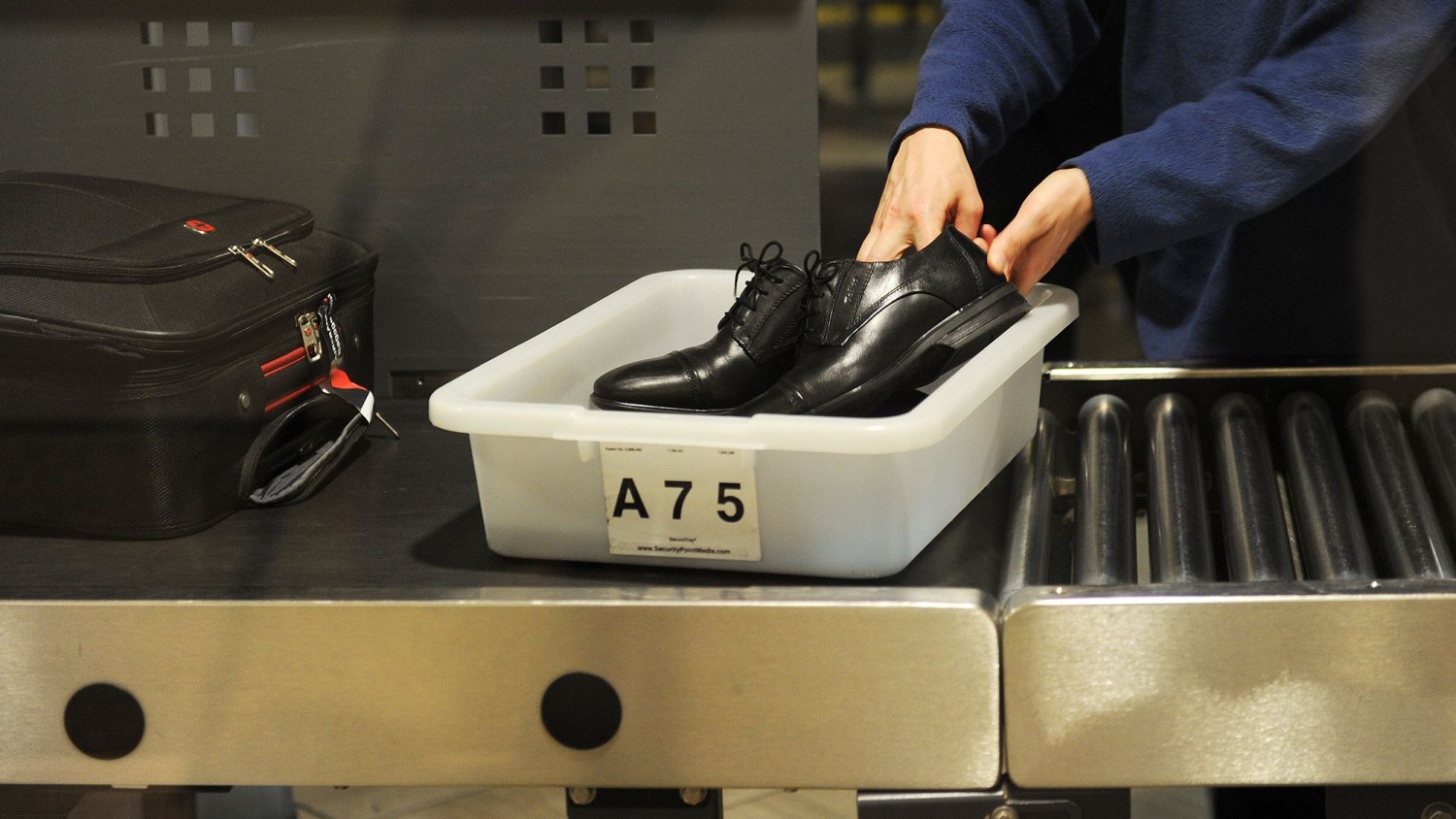 An air traveler places his shoes in a bin before passing through a TSA checkpoint at Los Angeles International Airport in 2014.  Robyn Beck/AFP/Getty Images/FILE