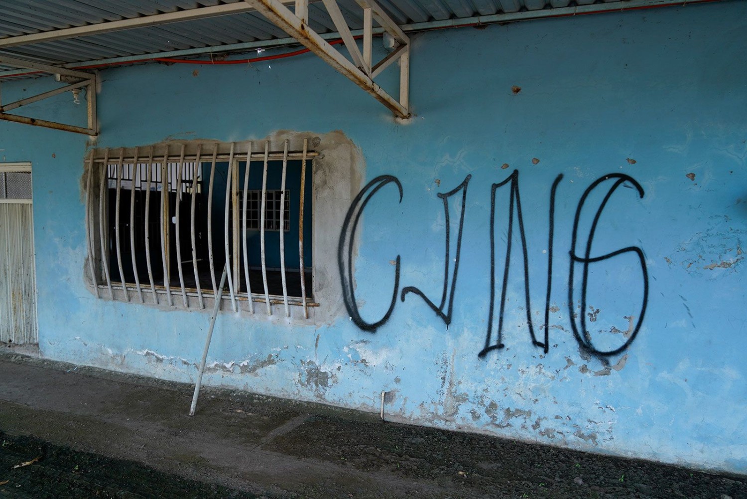 The letters "CJNG" for the group's formal name, Jalisco New Generation Cartel, cover the facade of an abandoned home in El Limoncito, in the Michoacan state of Mexico, Oct. 30, 2021. Eduardo Verdugo/AP/File