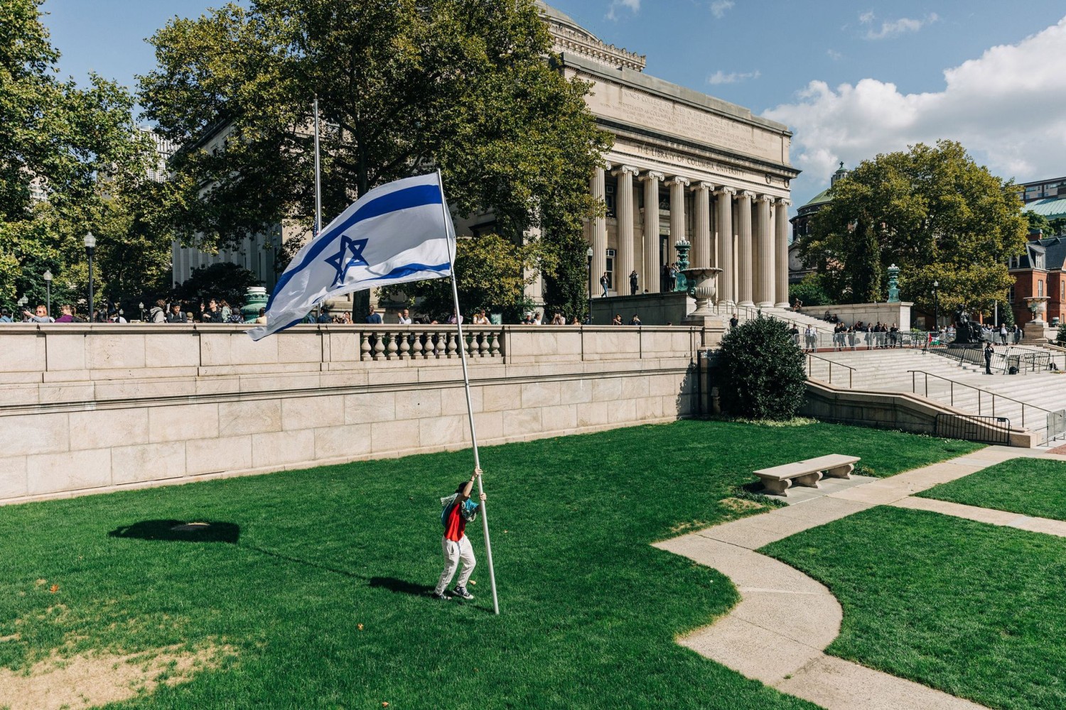 A man hoists an Israeli flag at Columbia University, in New York.Photograph by Jeenah Moon / NYT / Redux