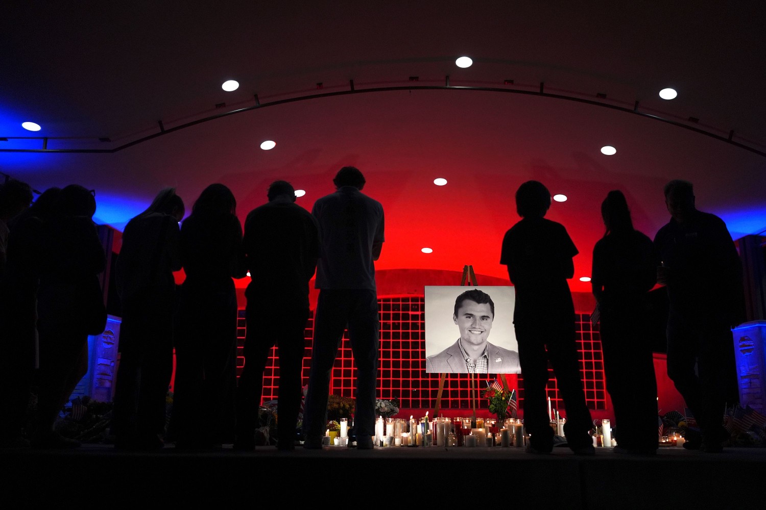 People look at a photo of Charlie Kirk, the CEO and co-founder of Turning Point USA, who was shot and killed, at a vigil in his memory, on September 11, 2025, in Orem, Utah.  Lindsey Wasson/AP