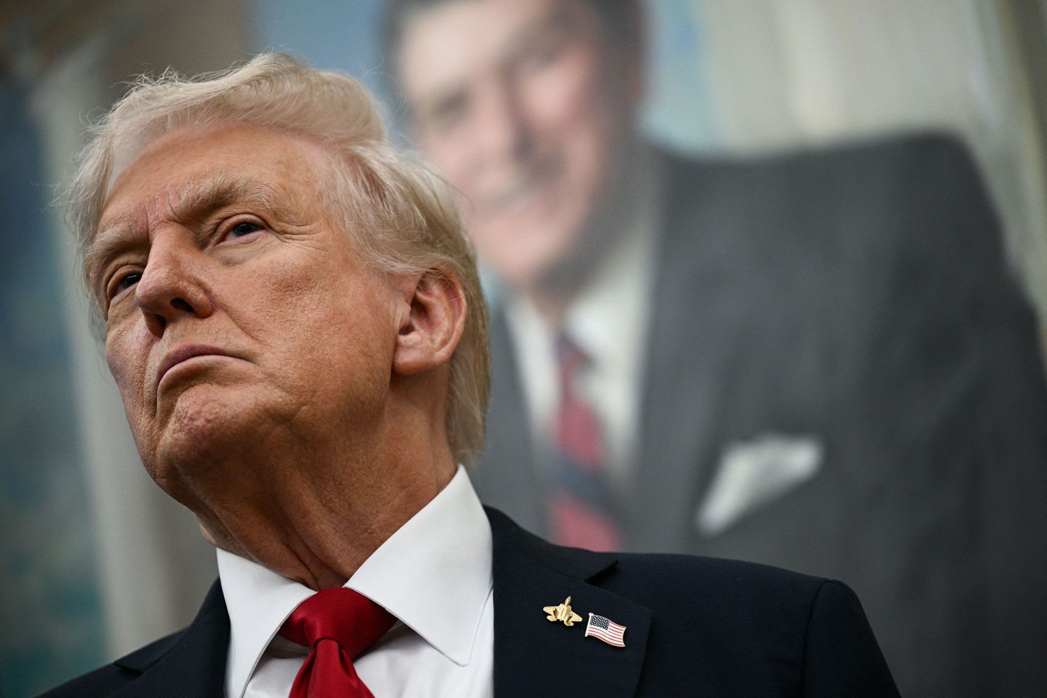 President Donald Trump stands in the Oval Office of the White House, on Tuesday.  Brendan Smialowski/AFP/Getty Images