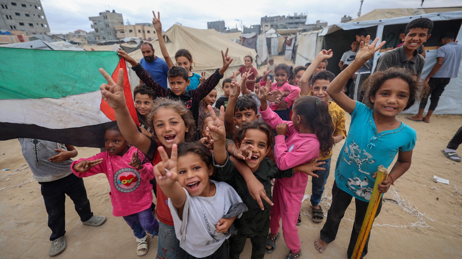 Des enfants palestiniens célèbrent l'annonce de l'accord sur Gaza dans un camp pour personnes déplacées à Nuseirat, dans le centre de la bande de Gaza, le 9 octobre 2025.  Photo : Getty Images / Eyad Baba