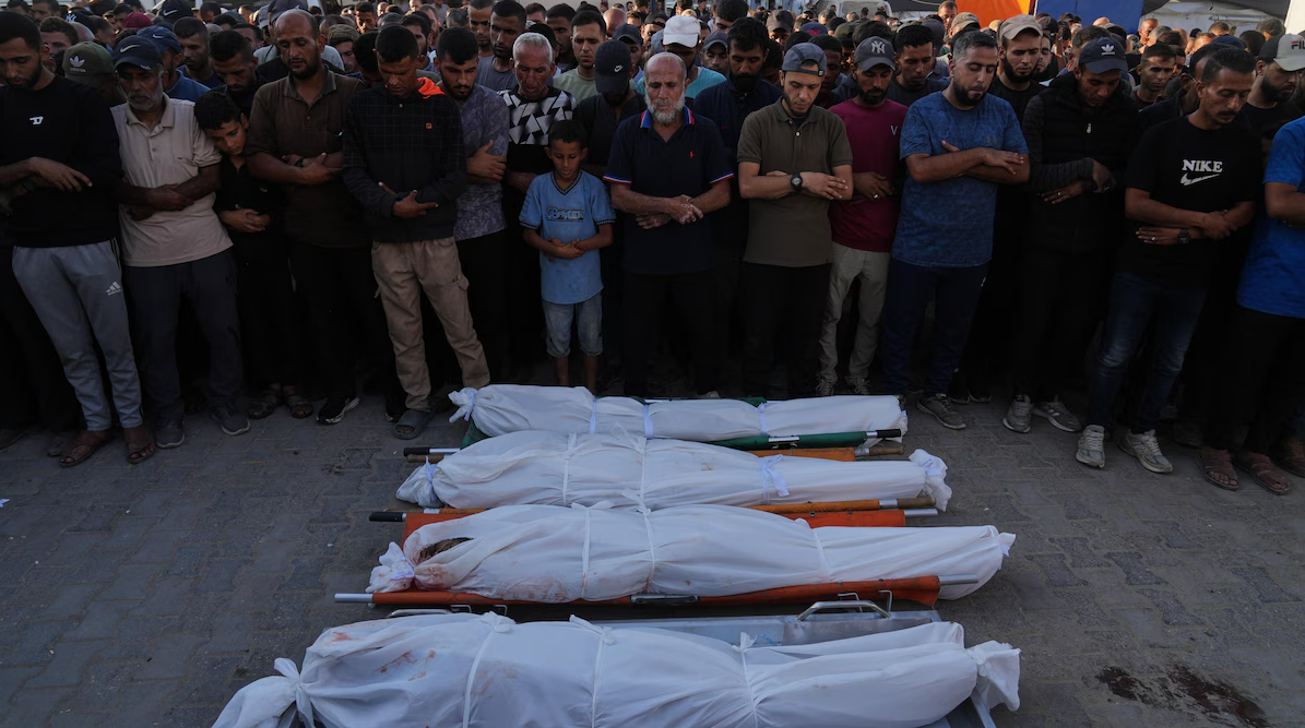 Des Palestiniens se recueillent devant les corps de proches tués par des tirs israéliens, le dimanche 19 octobre 2025.  Photo : AP / Abdel Kareem Hana