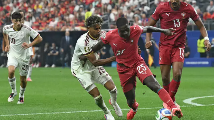 Lamine Yamal au duel avec Nuno Mendes lors de Portugal-Espagne en 8e de finale de la Coupe du monde. © Ronaldo Schmidt, AFP