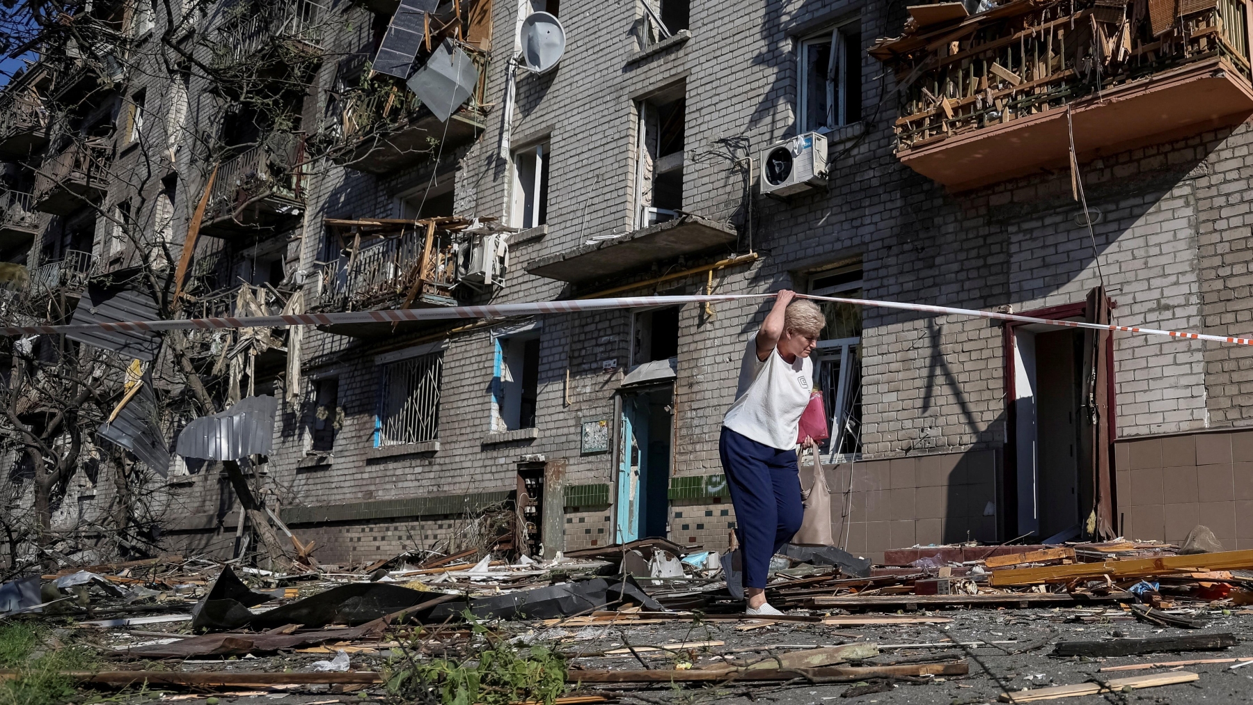 Une femme marche à proximité d'un immeuble endommagé par une frappe russe, à Kiev, le 2 juillet 2026.  Photo : Reuters