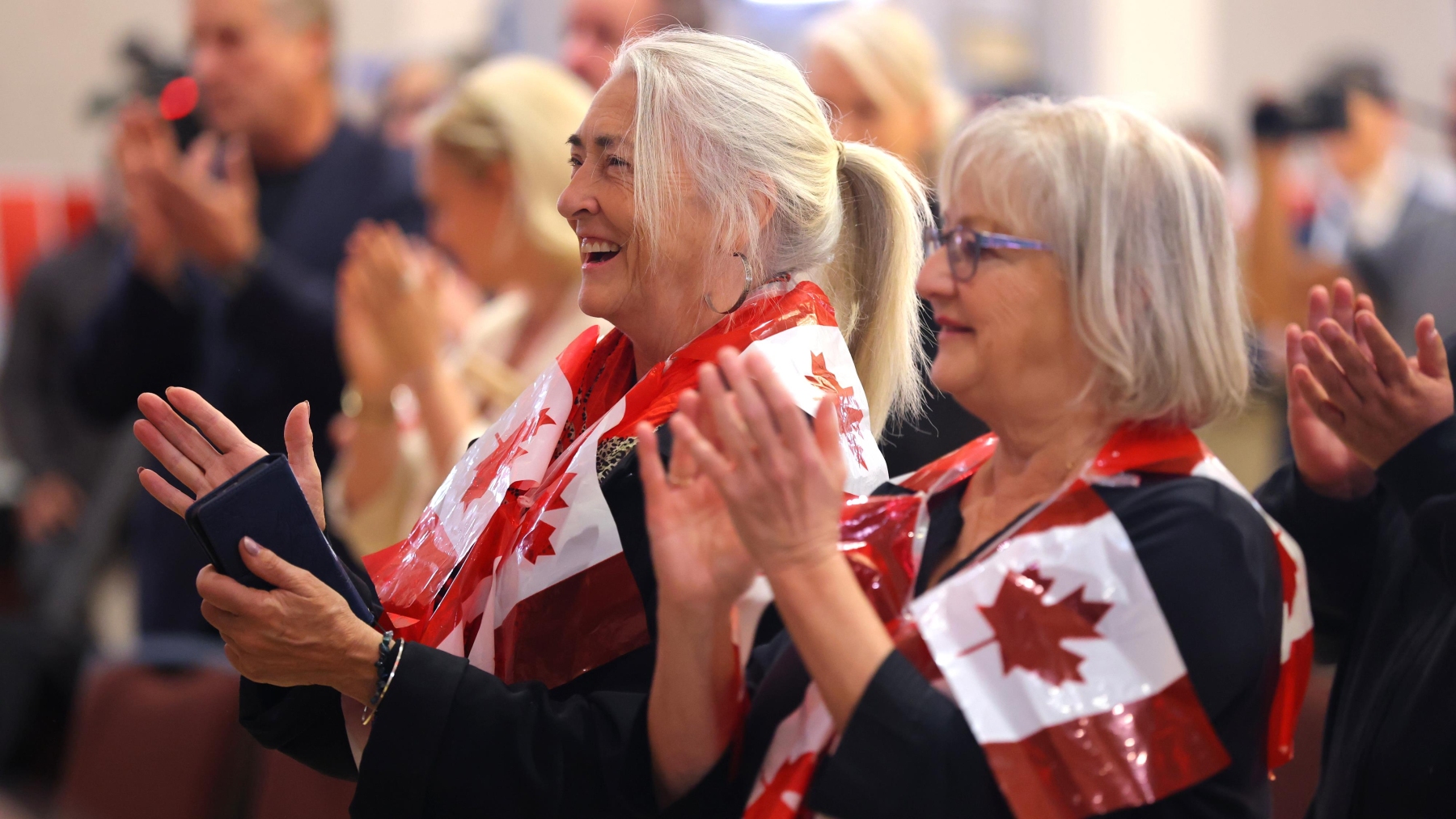Des partisans applaudissent les résultats durant un rassemblement en faveur du Canada, à Edmonton, le 19 octobre 2026.  Photo : La Presse canadienne / James Maclennan