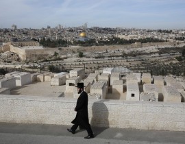 Ultra-Orthodox Jewish man walks near the ancient Jewish cemetery on the Mount of Olives overlooking the old city of Jerusalem on Dec. 5, 2017. Speculation in the media have suggested that US President Donald Trump will soon announce that Jerusalem sh