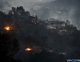 A mansion that survived a wildfire sits on a hilltop in the Bel Air district of Los Angeles after a dangerous new wildfire erupted in the area and across Southern California.