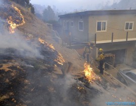 Firefighters put out flames near a home along Kagel Canyon Road at the Creek fire on Dec. 5, 2017, in Lake View Terrace area of Los Angeles .