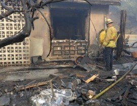 A firefighter checks damage to a home at Lake View Terrace area of Los Angeles on Dec. 5, 2017.