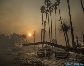 Smoke rises behind a leveled apartment complex as a wildfire burns in Ventura, Calif., on Dec. 5, 2017. Over 100 structures have burned so far in Ventura County, officials said.