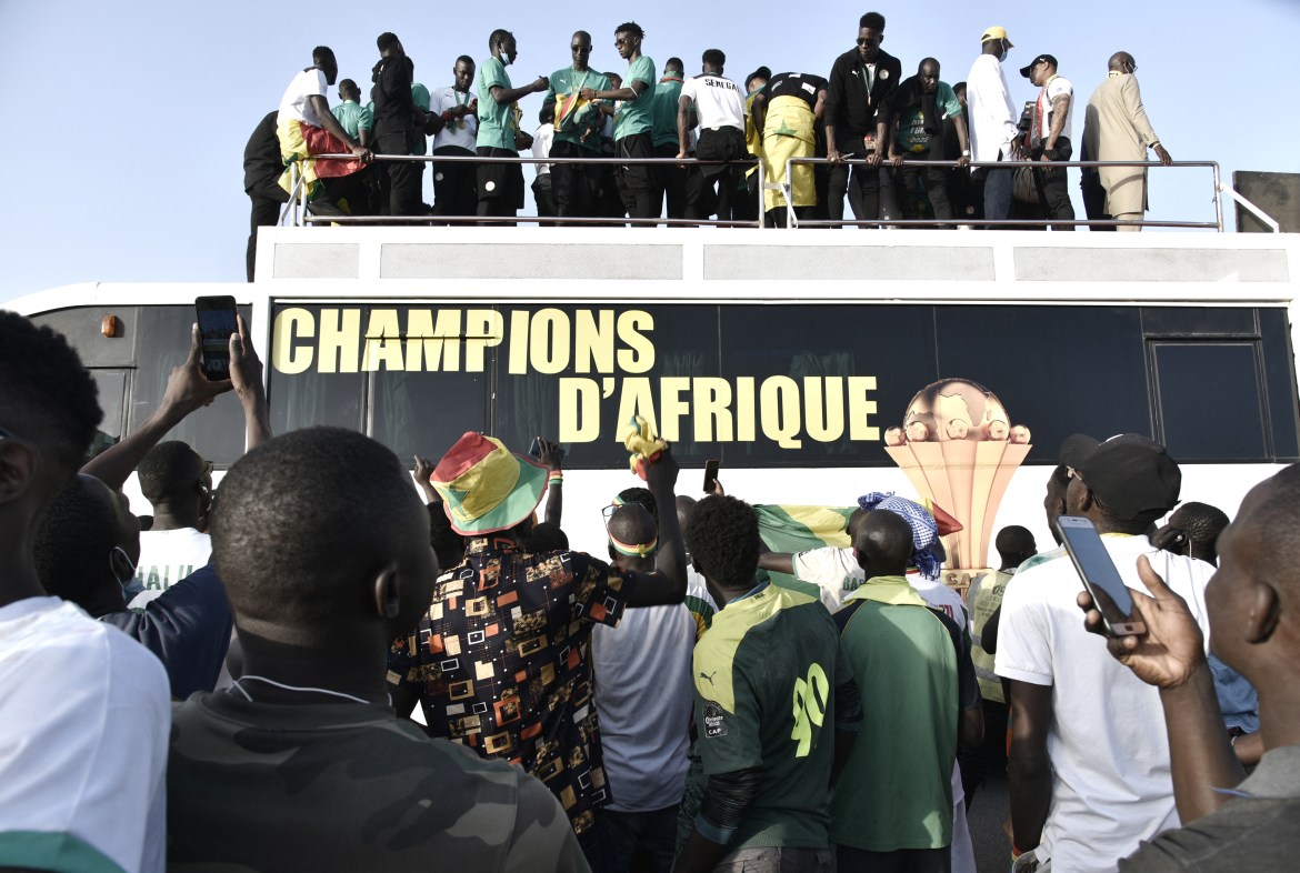 Supporters surround the bus with the national football team in Dakar. [Seyllou/AFP]